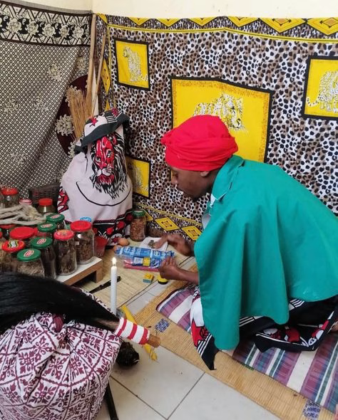 Inyanga herbalist mixing traditional African herbs for healing.