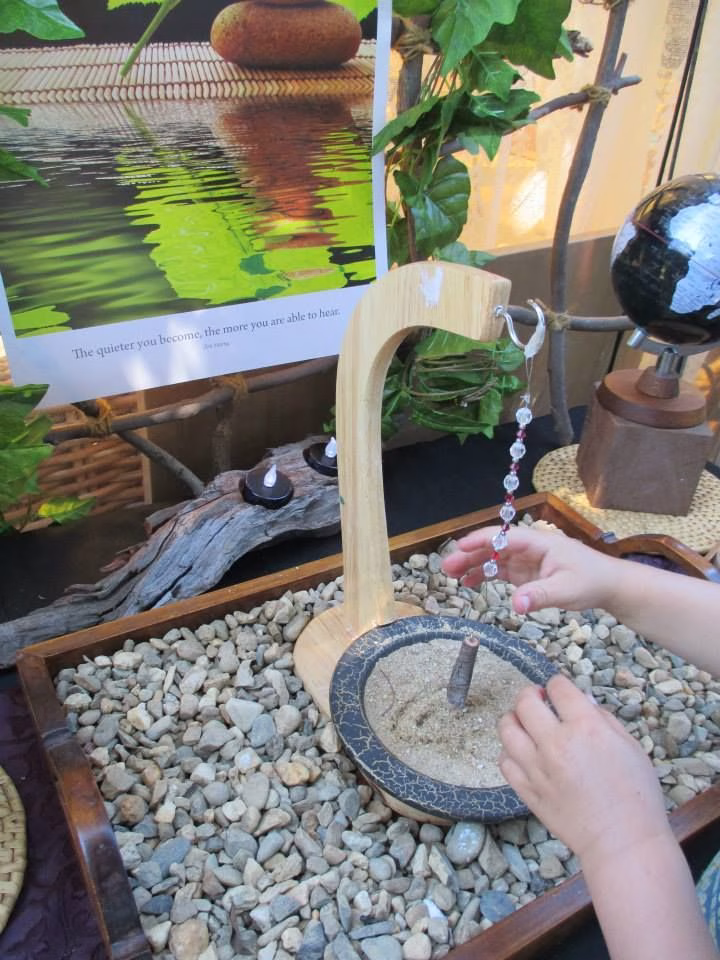 Person holding a pendulum, focusing on a question for intuitive answers.
