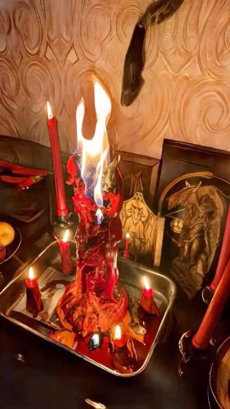 Read candles burning on a silver plate sitting on wooden table, representing online love psychics